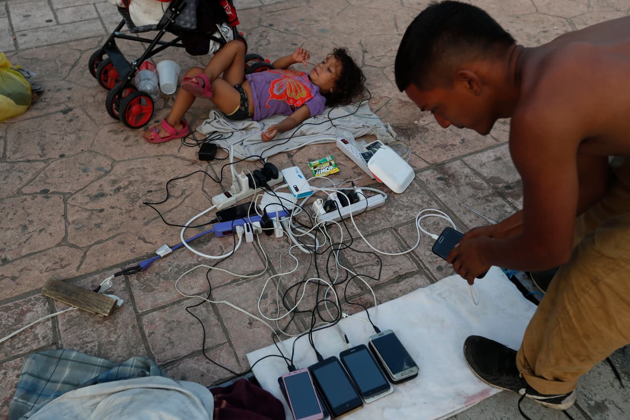 Los migrantes hacen campamentos improvisados, como este en Escuintla, en donde descansan, cargan sus teléfonos móviles y tratan de higienizar a sus hijos.
