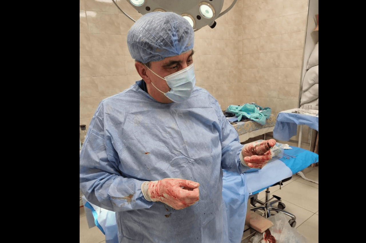 El médico militar Andrii Verba sostiene la granada, después de haberla extraído del cuerpo del soldado.