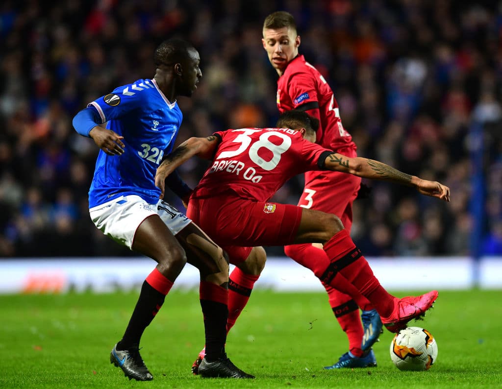 Karim Bellarabi aguanta el balón ante la presión de Glen Kamara y consigue una falta a favor.