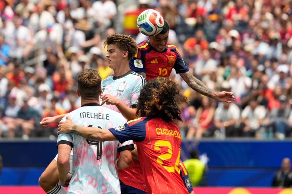 El español Pedro Porro y el belga Charles De Ketelaere saltan para disputar el balón.