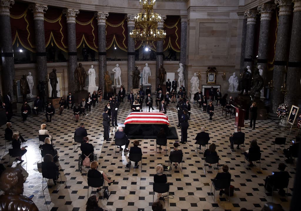 Miembros del Congreso sentados ante el féretro de Ruth Bader Ginsburg en el Salón de las Estatuas del Capitolio.