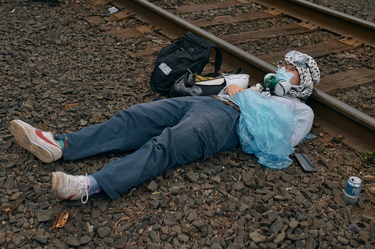 Un manifestante toma una siesta sobre las vías del tren frente al centro de detención Delaney Hall el sábado 30 de mayo de 2026 en Newark, Nueva Jersey.