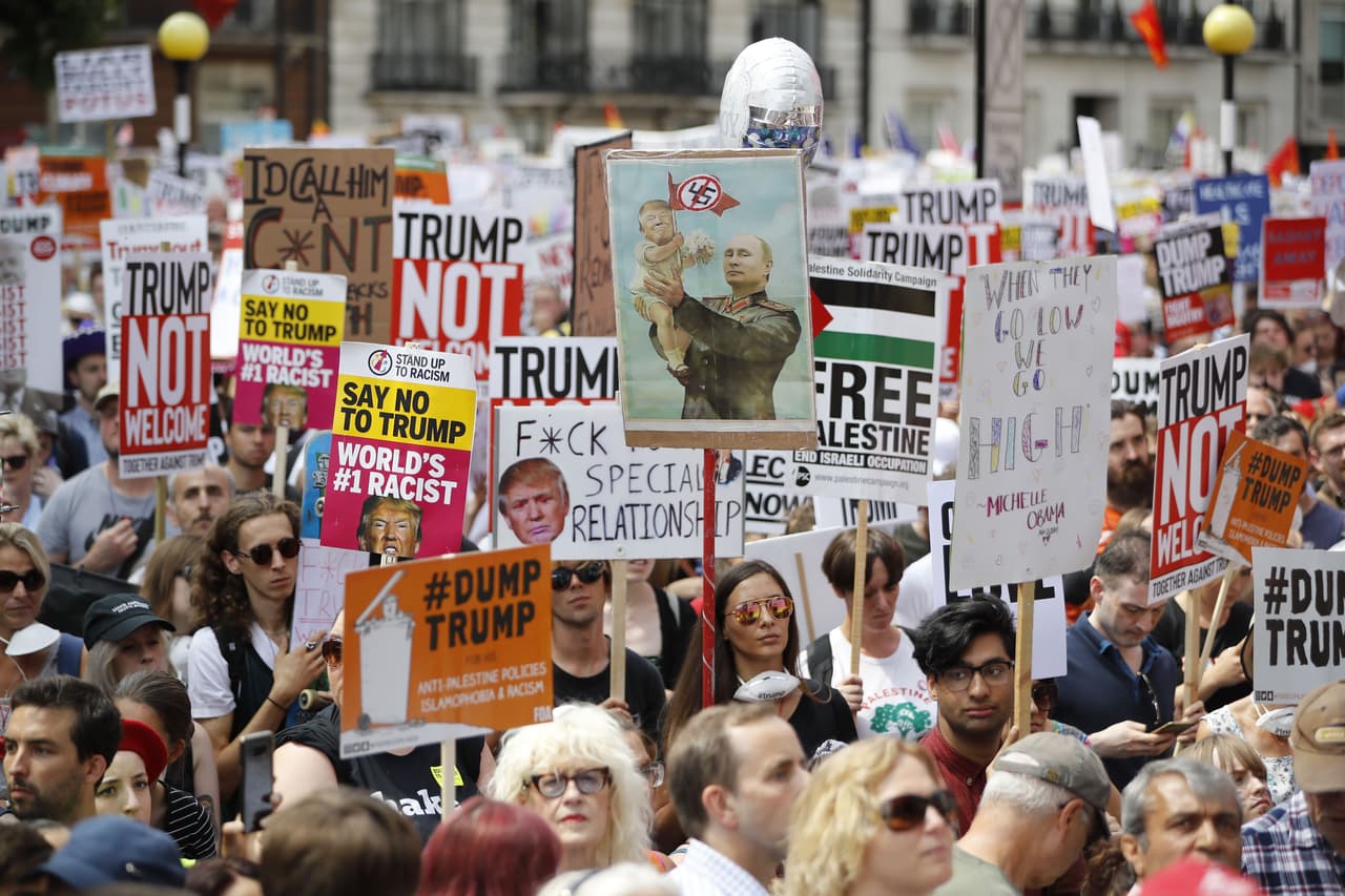En el mar de carteles que llevaban los manifestantes destaca una composición fotográfica de Vladimir Putin levantando a Trump. Al lado se puede leer otro que cita una frase de la ex primera dama Michelle Obama: “Cuando ellos van hacia abajo, nosotros subimos”.