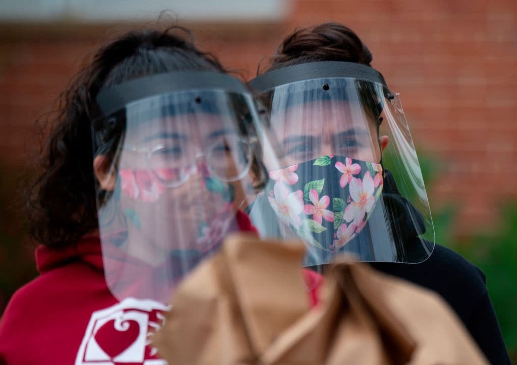 Personas con escudos plásticos faciales.