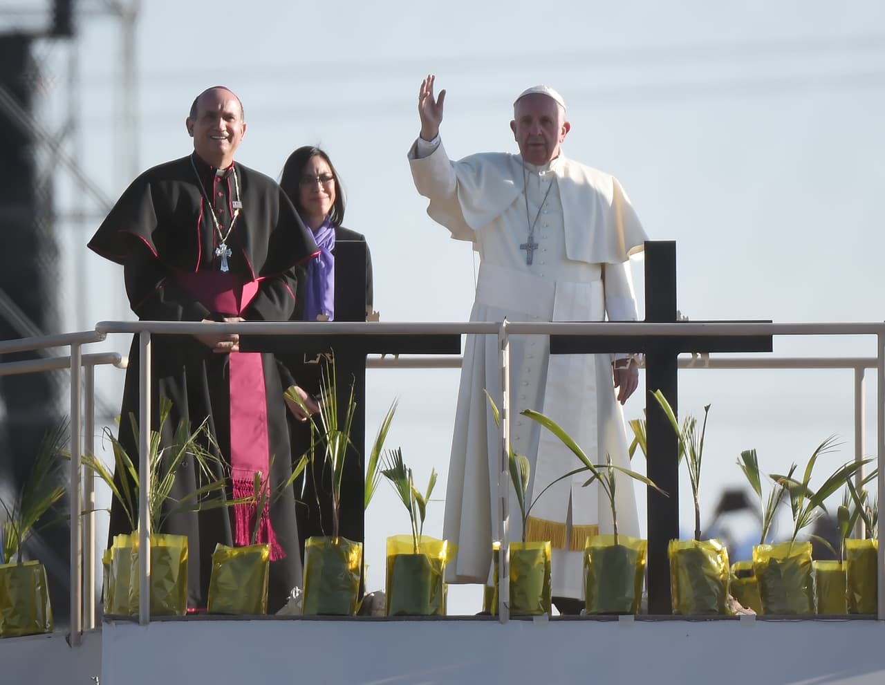 Francisco se encuentra sobre una plataforma en México como él bendice a un grupo de migrantes que se encuentran del lado estadounidense de la frontera.