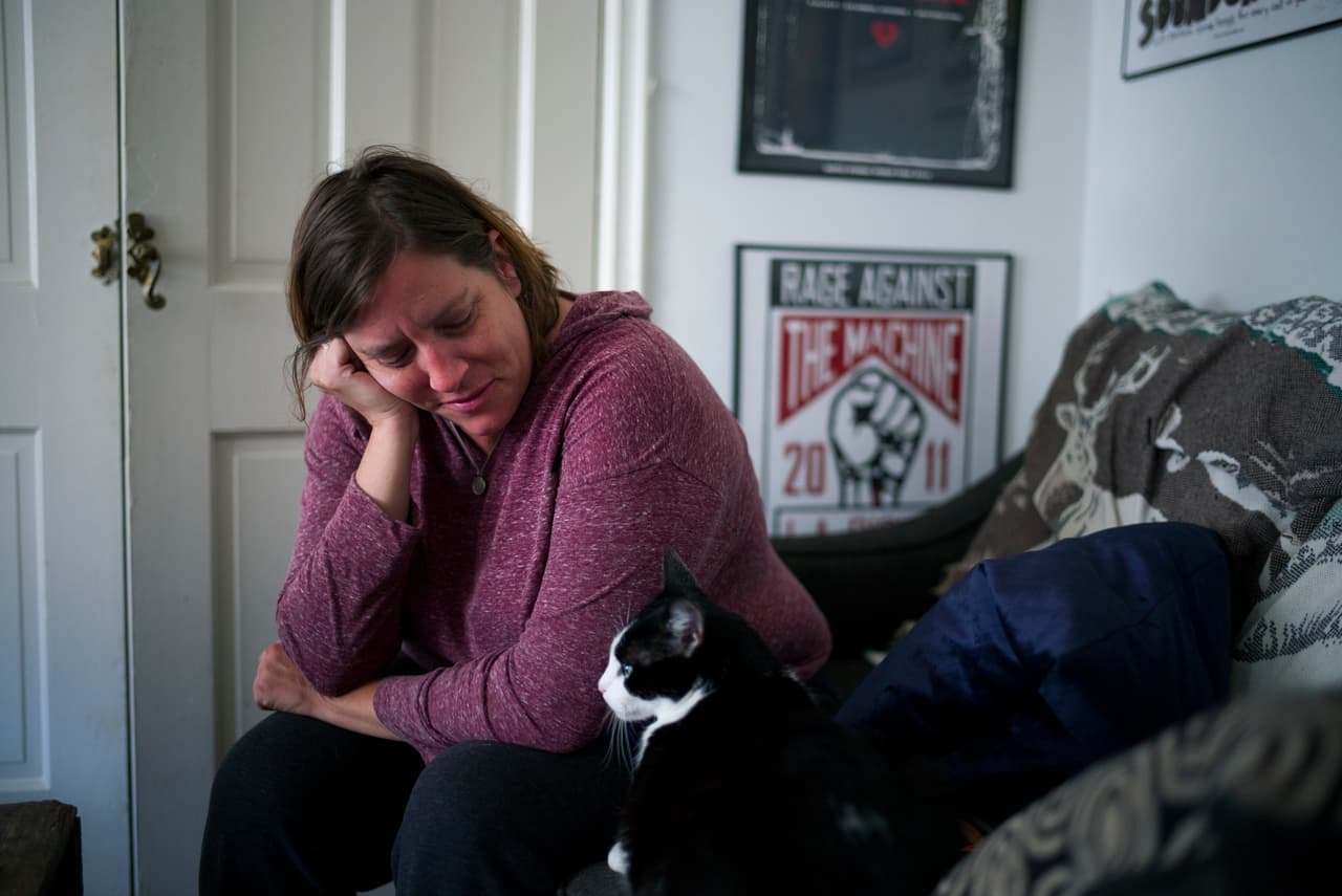 In this Sunday, May 22, 2016 photo, Mandy Pifer looks at her cat while resting in her apartment in Los Angeles. Nearly six months ago, Pifer's boyfriend Shannon Johnson was one of 14 people killed in the San Bernardino terrorist attack. As a responder with the Los Angeles mayors crisis response team, Pifer has spent the last six years comforting others in the aftermath of tragedy. But after the attack, Pifer found herself dealing with a crushing, overwhelming sadness. (AP Photo/Jae C. Hong)