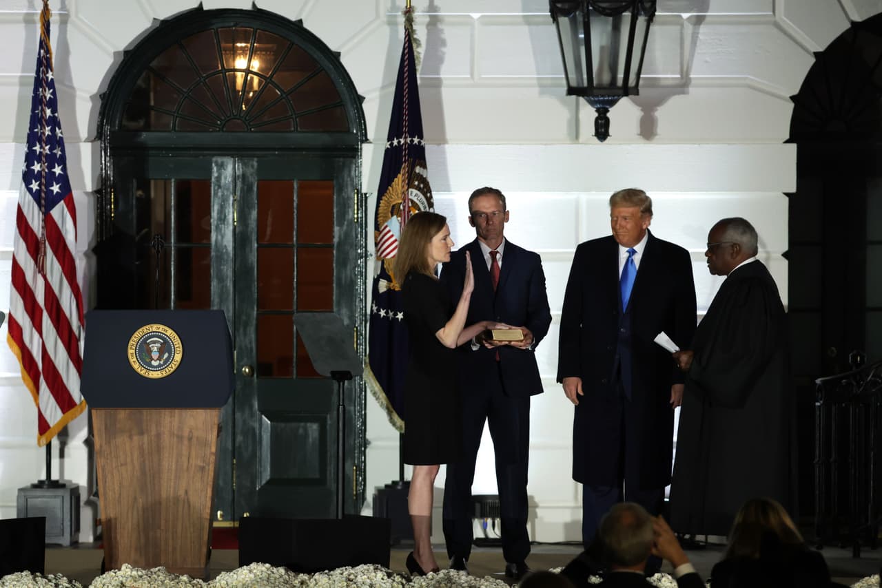 La jueza
<a href="https://www.univision.com/temas/amy-coney-barret">Amy Coney Barrett</a> es juramentada por el juez de la Corte Suprema Clarence Thomas, durante un acto en el jardín sur de la Casa Blanca poco después de que fue confirmada por el Senado en una votación de 52-48.