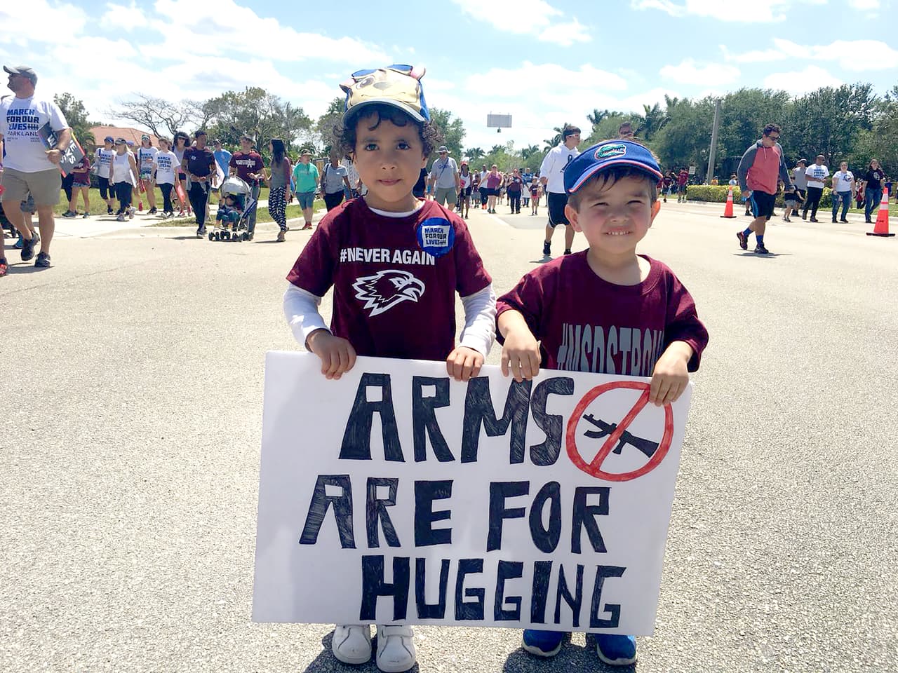 <b>Parkland, Florida.</b> “Las armas (brazos) son para abrazar”, se lee en el cartel que llevan unos pequeños en la manifestación realizada en el lugar donde sucedió el último tiroteo escolar.