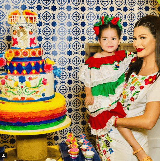 Giulietta posando junto a su mamá, junto a su pastel de cumpleaños.