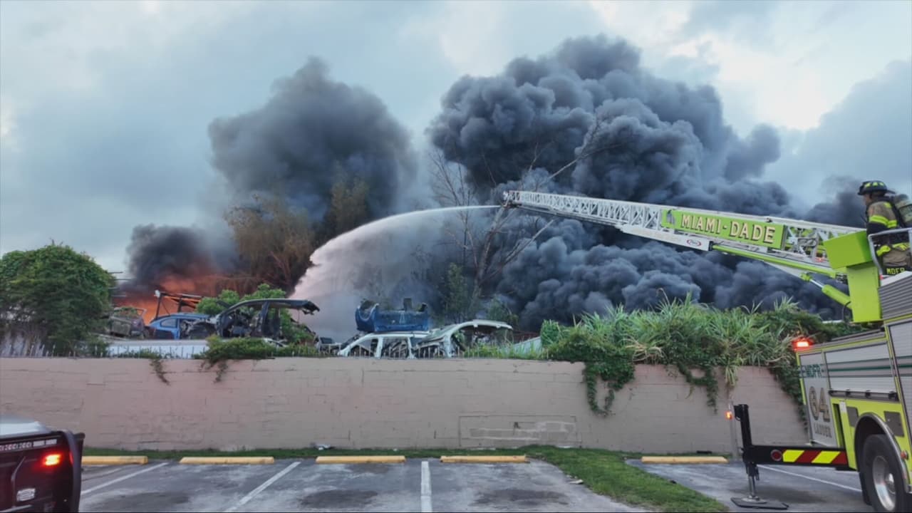 Bomberos trabajan para controlar voraz incendio en negocio de desguace de carros en Opa-locka