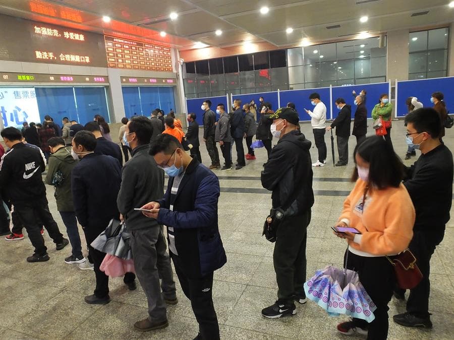 Viajeros hacen cola para comprar billetes de tren en una estación en Yichang, provincia de Hubei, China. Ochenta estaciones de ferrocarril de la provincia reanudaron el servicio de pasajeros el 25 de marzo de 2020.