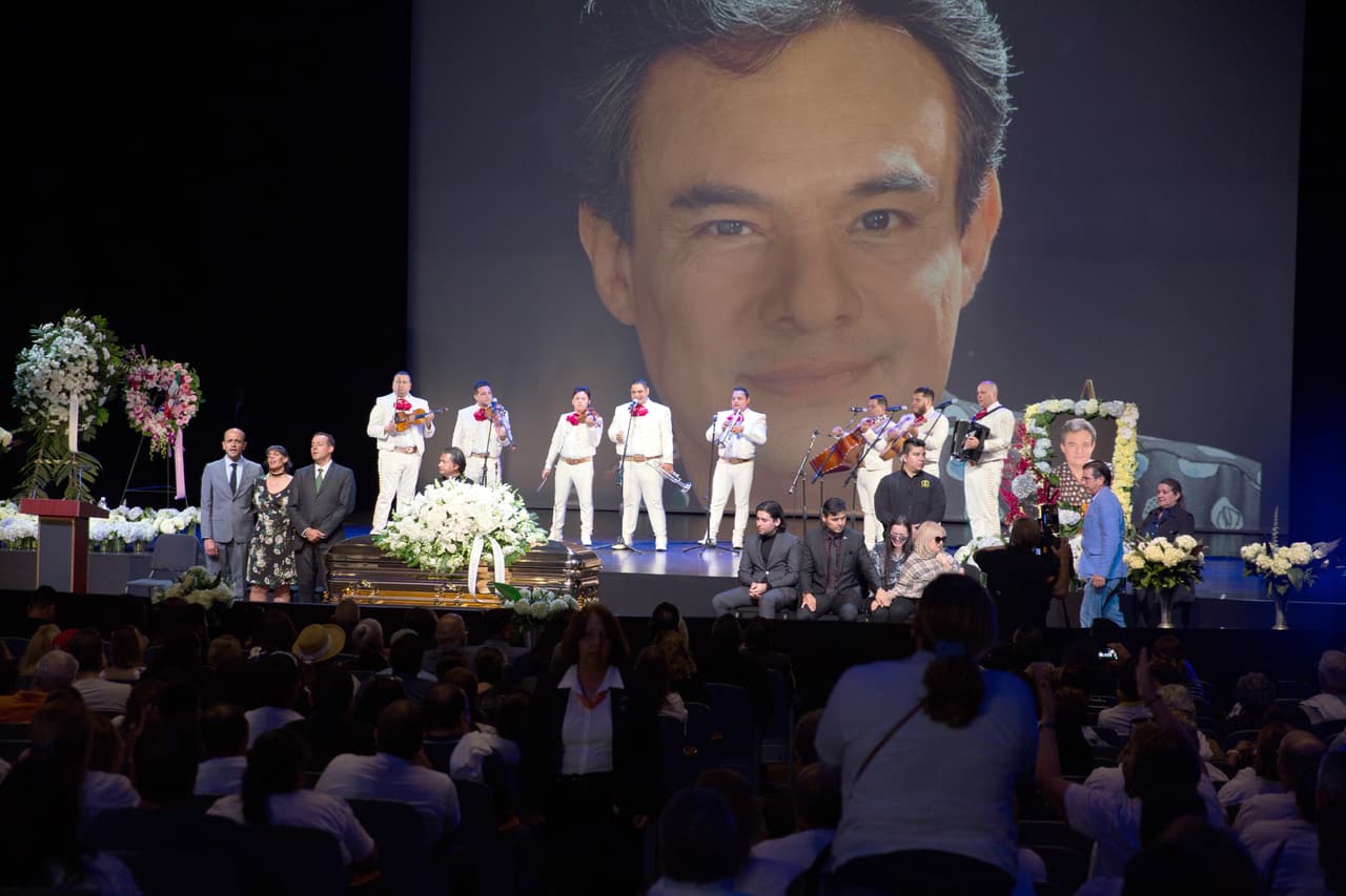 Los hijos y esposa de José José a cada lado del féretro en el auditorio.