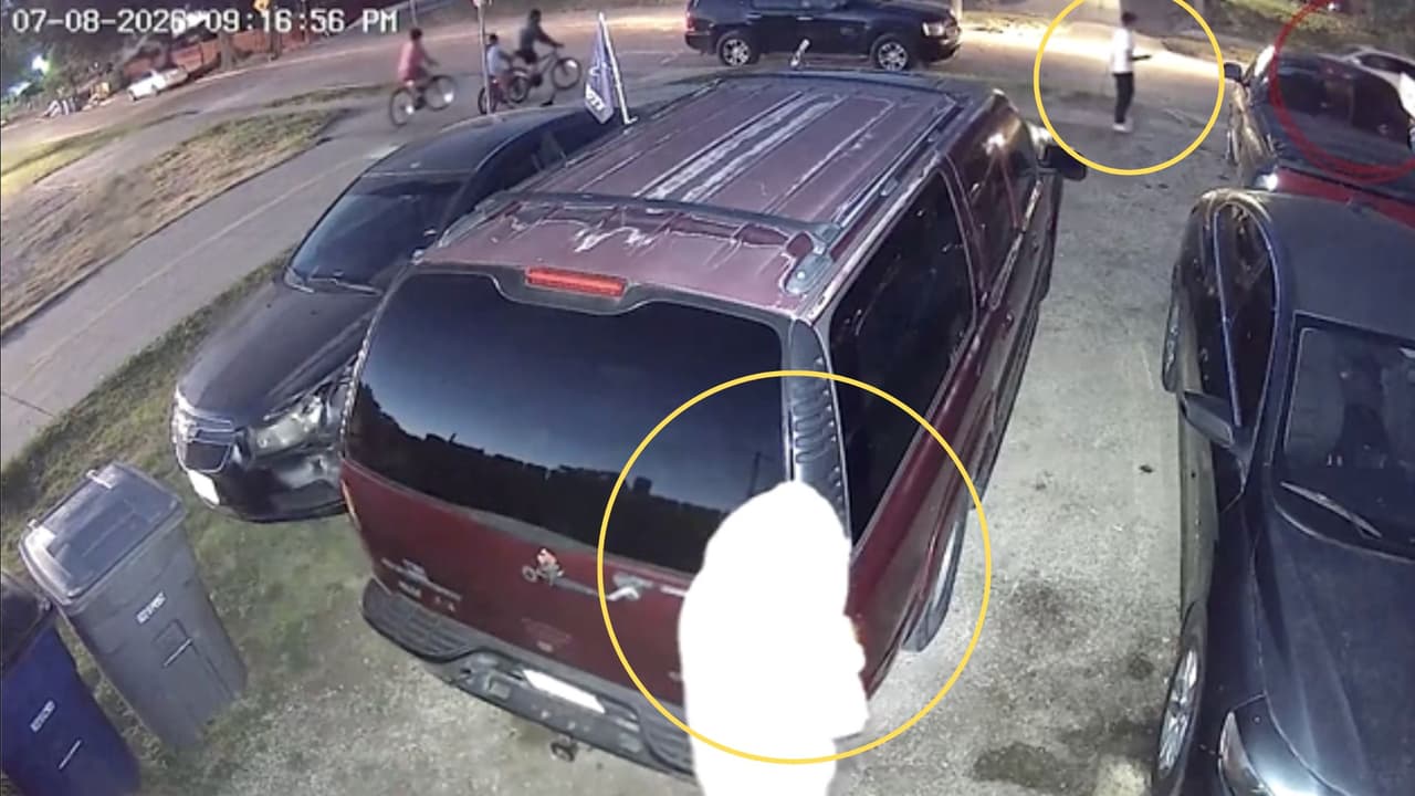 Momentos antes de acercarse al auto, la persona camina por la acera mientras otra, con el rostro cubierto, observa sus movimientos.