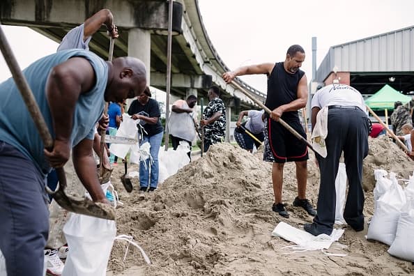 Habitantes de Nueva Orleans llenan bolsas de arena para proteger sus casas de la posible inundación.