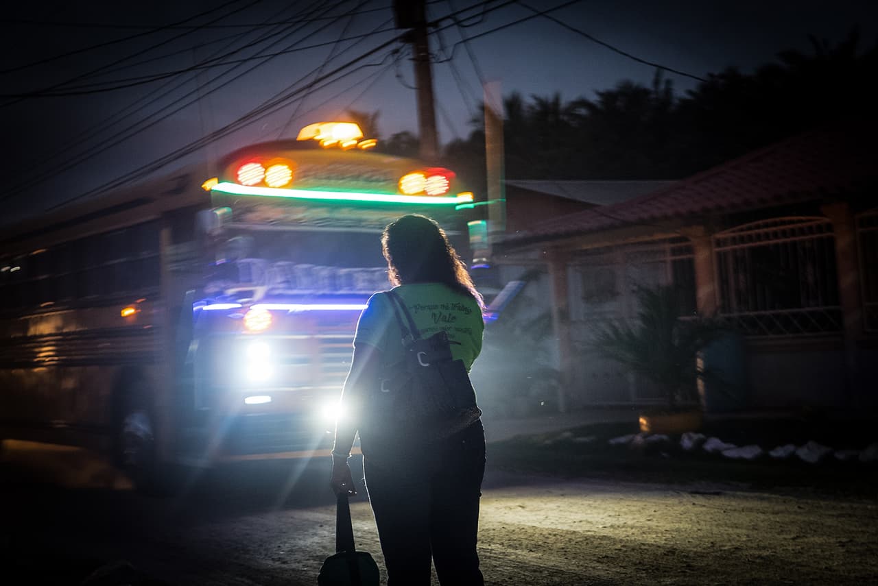 Before dawn, Gómez waits for the company bus near her home. Even when on strike, she shows up to work, fearing she will be replaced if absent.