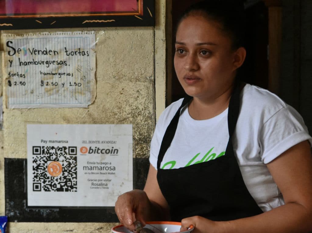 Celina Fuentas atiende a un cliente en su tienda donde acepta bitcoins en El Zonte, a 56 km al sureste de San Salvador, el 09 de junio de 2021.