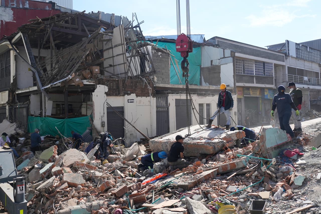 Los equipos especiales aseguran con cadenas una sección de la estructura colapsada de un edificio antes de que sea izada por una grúa, en Pereira, Colombia, el martes 11 de agosto de 2026. (Foto AP/Fernando Vergara)