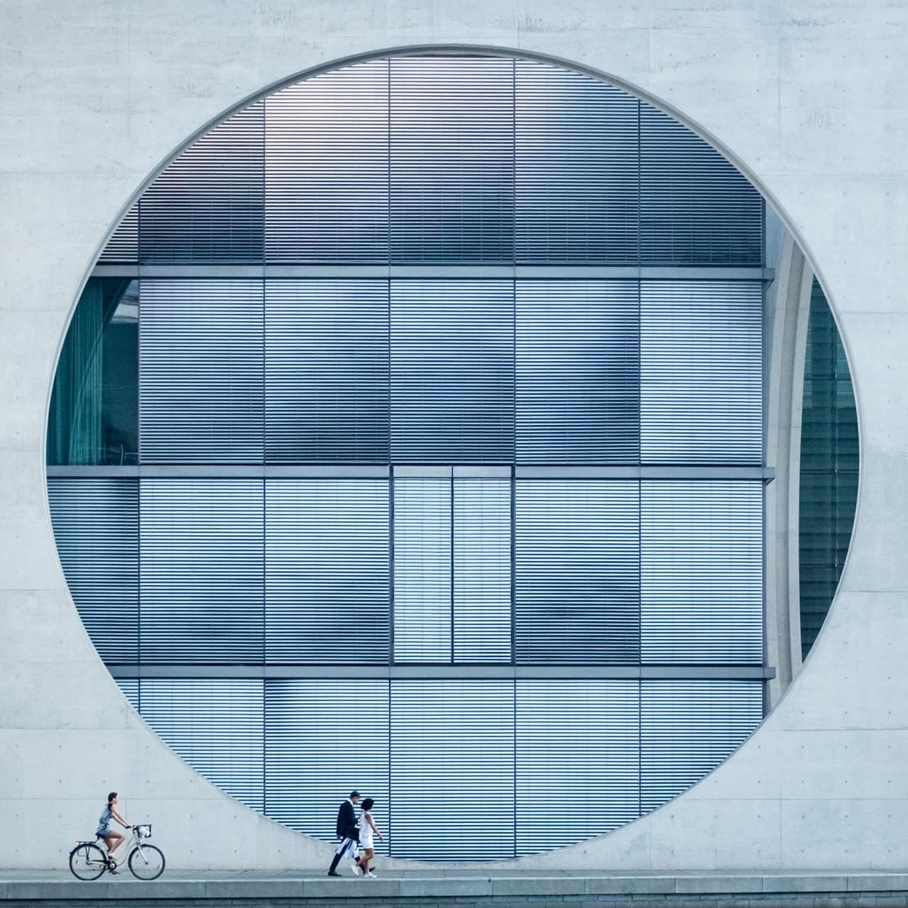 Una pareja seguida de una ciclista frente a un edificio de Berlín. Premio Sony 2017 en la categoría Abierta/Arquitectura.