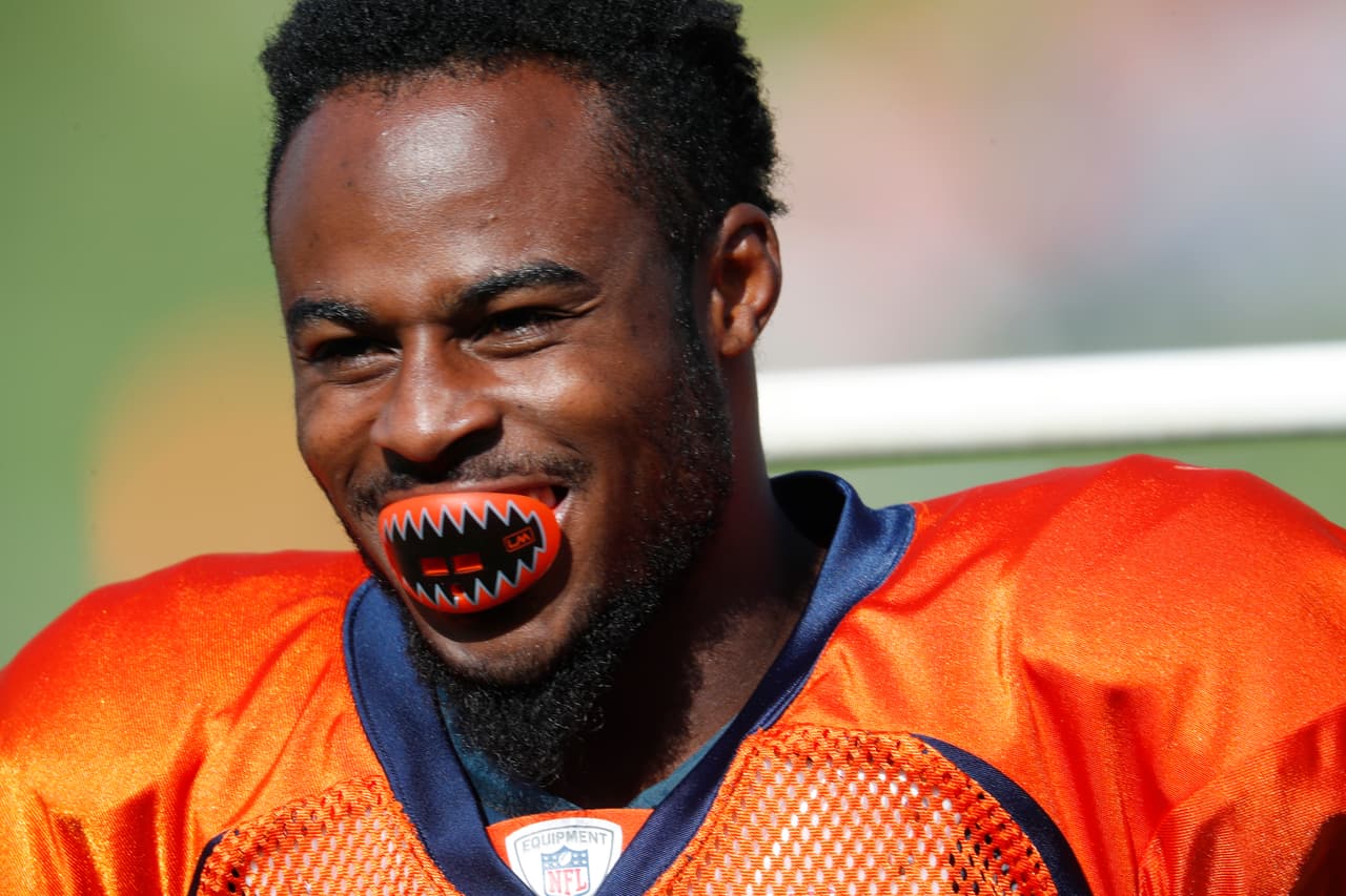 El receptor abierto de los Broncos de Denver Isaiah McKenzie sonríe durante el entrenamiento del equipo este lunes mientras muestra su peculiar protector bucal, con diseño 'terrorífico'.