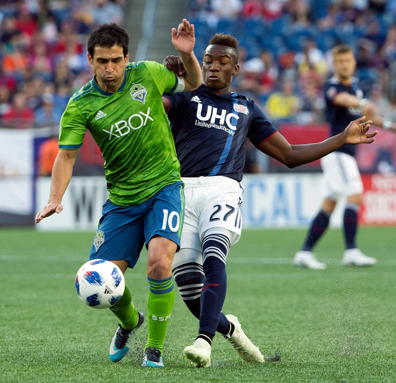 Jul 7, 2018; Foxborough, MA, USA; Seattle Sounders midfielder Nicolas Lodeiro (10) battles for the ball with New England Revolution midfielder Luis Caicedo (27) during the first half at Gillette Stadium. Mandatory Credit: Winslow Townson-USA TODAY Sports