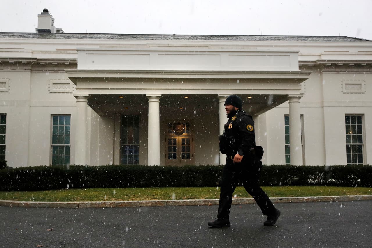 A brief snow falls outside the West Wing of the White House as a uniformed Secret Service officer walks past, Wednesday Jan. 9, 2019, in Washington. (AP Photo/Jacquelyn Martin)