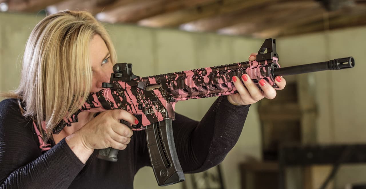 In this photo taken June 24, 2016, Dara Humphries, an NRA and Glock firearms instructor, poses for a portrait in Gainesville, Ga., holding an AR-platform rifle at a gun range. An estimated 8 million AR-style guns have been sold since they were first introduced to the public in the 1960s, and about half of them are owned by current or former members of the military or law enforcement, according to the National Shooting Sports Foundation, which represents gunmakers. (AP Photo/Lisa Marie Pane)