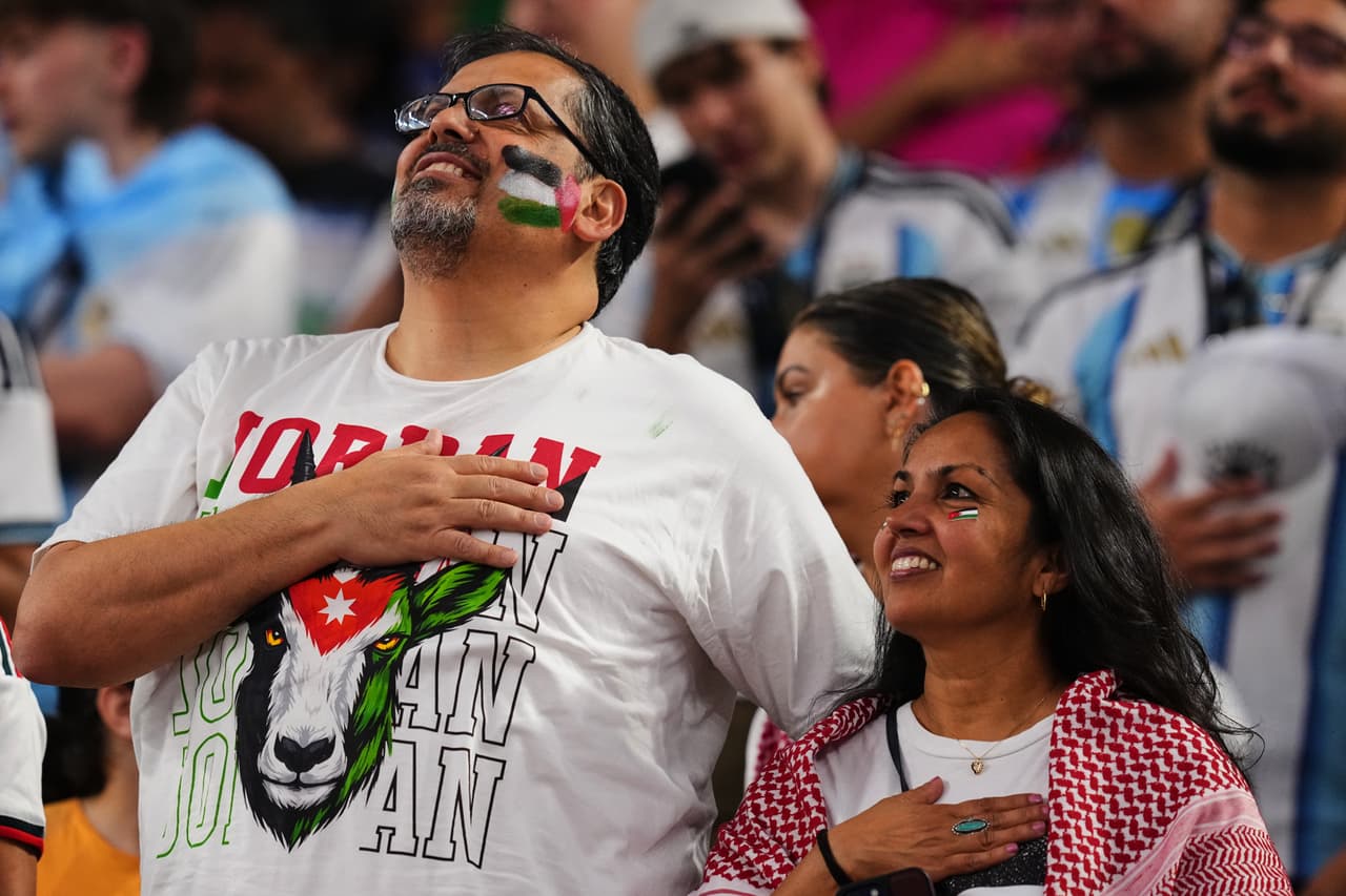 Aficionados de Jordania cantan el himno de los Estados Unidos.