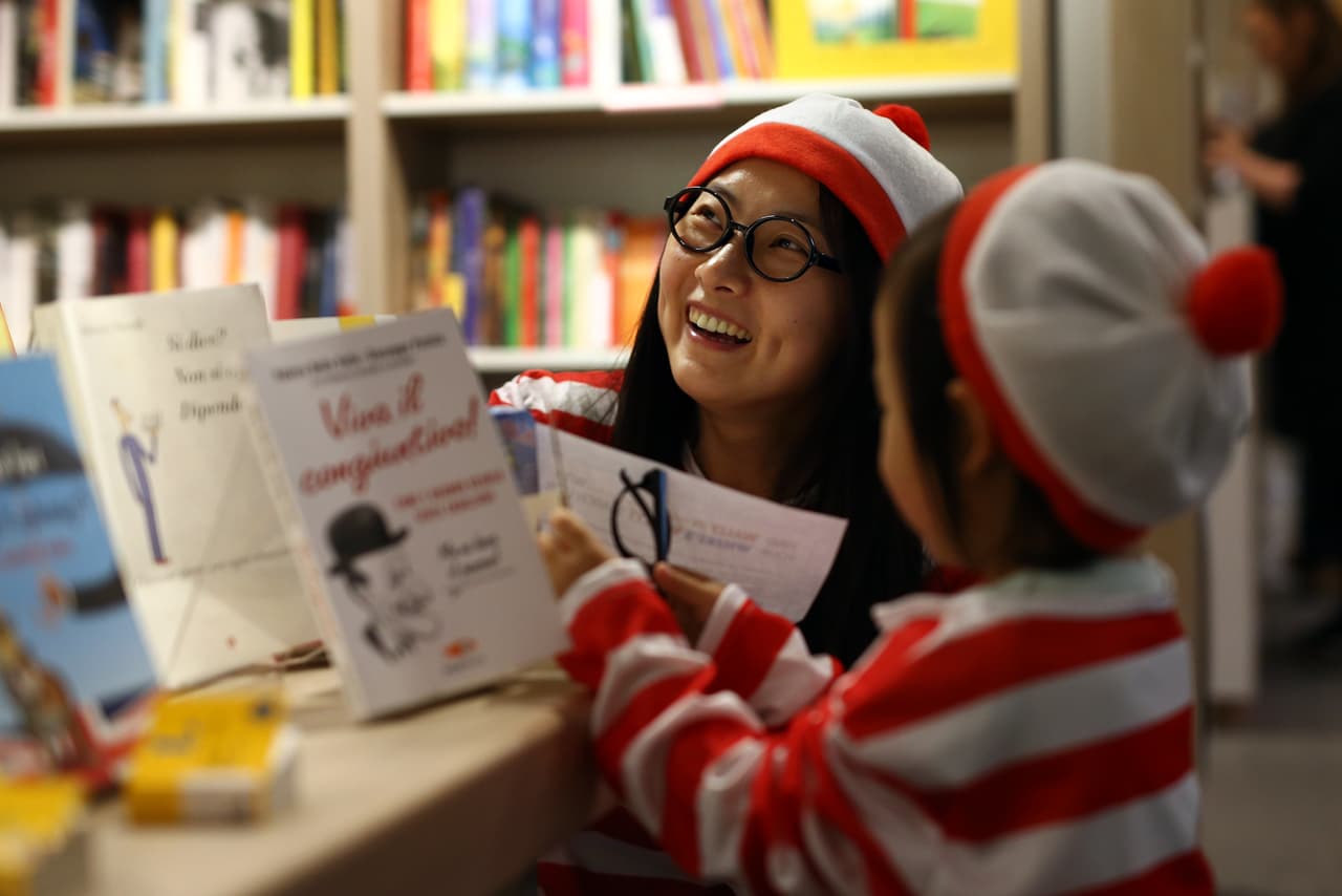 LONDON, ENGLAND - JULY 25: A mother and daughter dressed as 'Where's Wally?' characters, also known as 'Where's Waldo?' in North America, take part in a competition to find Wally and his dog Woof at Foyles Bookstore on July 25, 2015 in London, England. The event marked the opening of 'Foyles Summer of Fun!' children's book festival where children's stories will be brought to life with immersive theatre experiences, making workshops and character visits from the likes of Shaun the Sheep and other popular children's characters. (Photo by Carl Court/Getty Images)