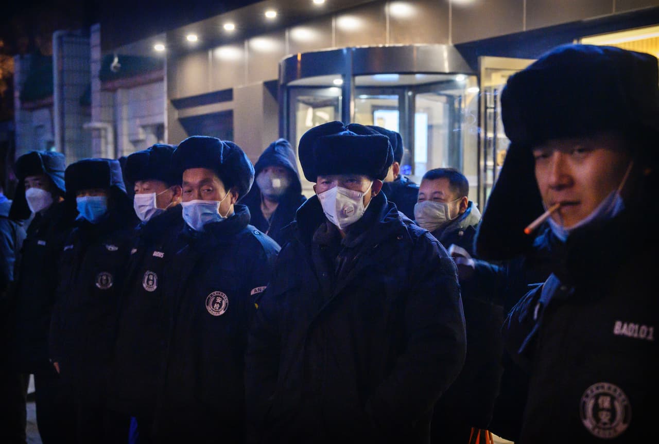 Guardias de seguridad con sus rostros cubiertos con mascarillas en Pekín.