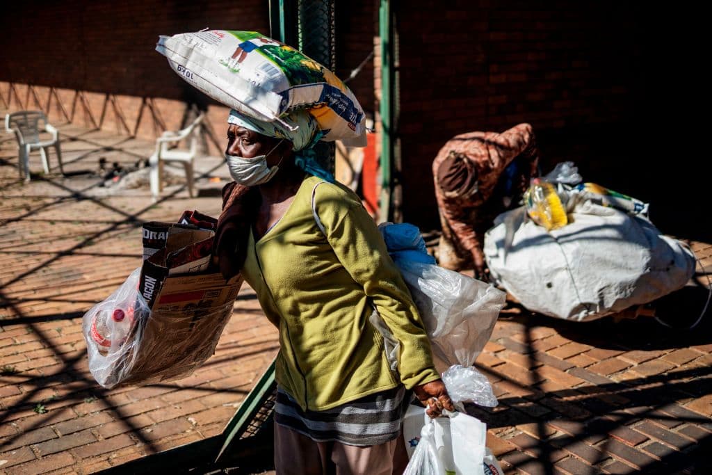 Una mujer recoge comida de un centro de distribución de alimentos en la provincia sudafricana de Gauteng, que registra más de 63,000 casos positivos.