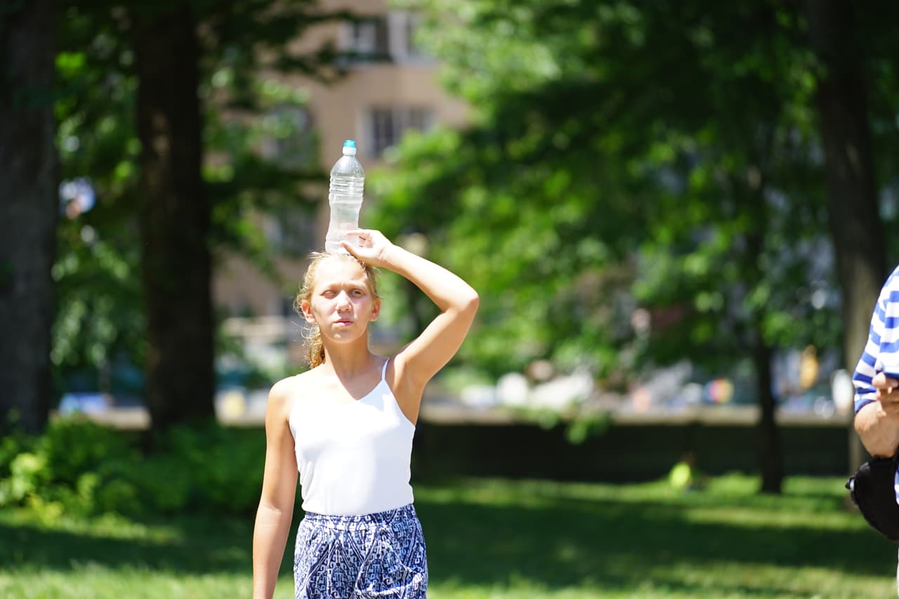 Turistas en Central Park como pueden se protegen del calor y la humedad.