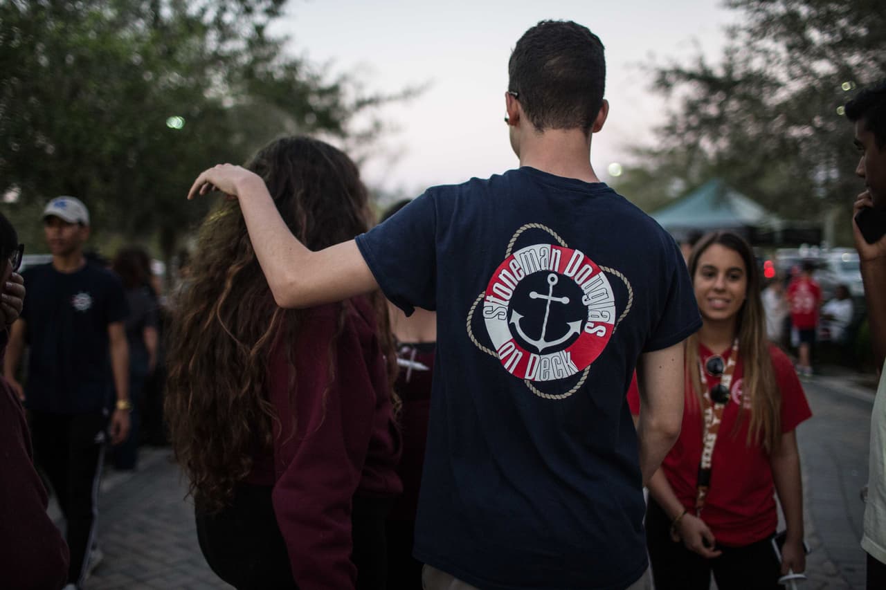 Armando Refuge, de 16 años, se puso la única playera que tenía de la escuela, del homecoming del año pasado, después de coordinarse con sus compañeros. Ha estado en esta escuela los últimos tres años. La tarde de la vigilia se reencontró con amigos que no veía desde antes del tiroteo.