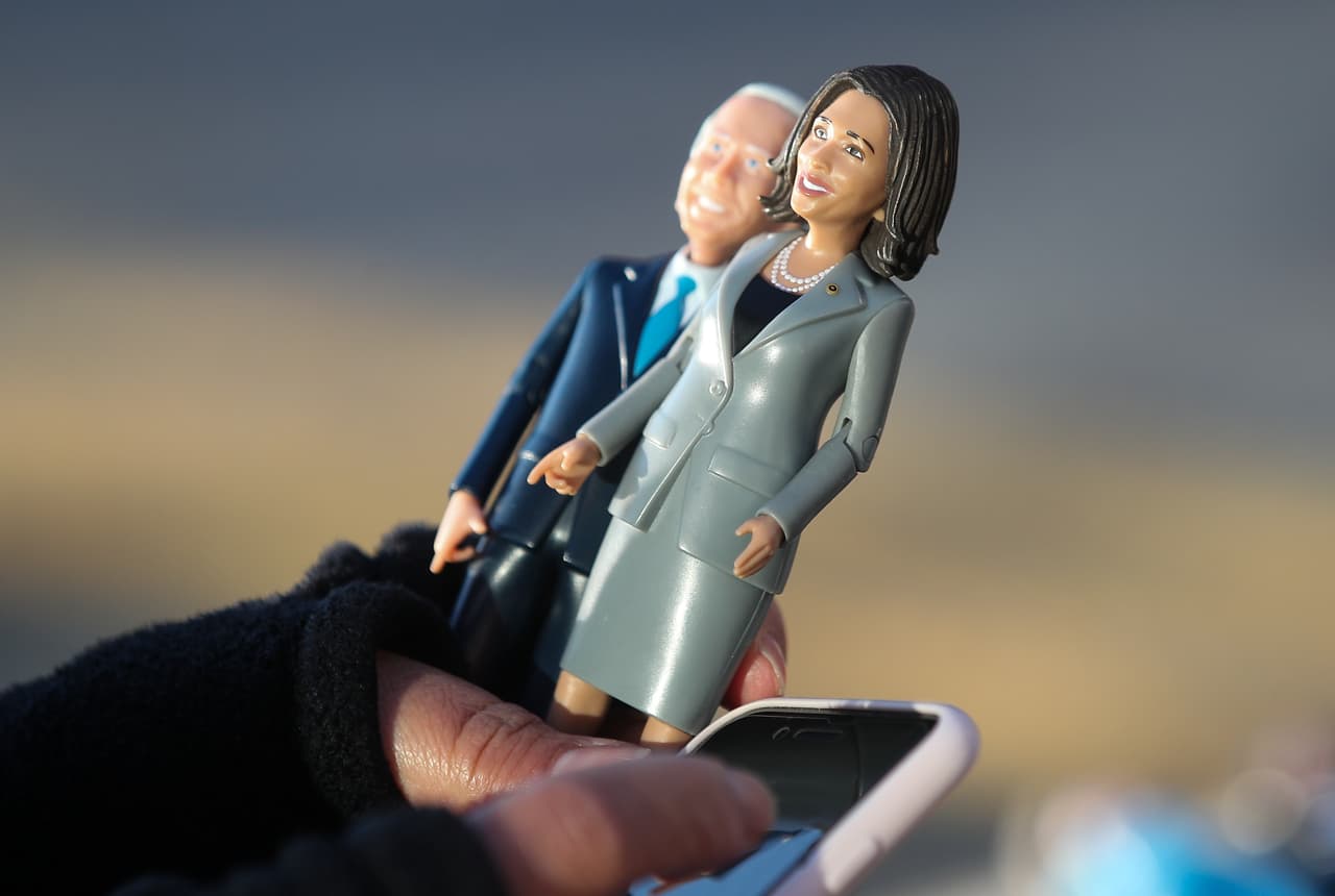 Muñecos con las figuras de Biden y Harris en las manos de una seguidora del nuevo presidente cerca del centro de Washington DC.