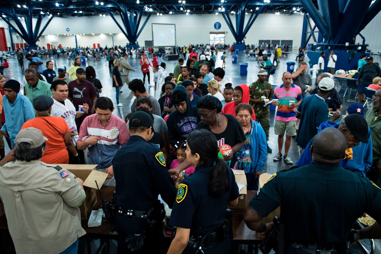 Flood victims gather for food at a shelter in the George R. Brown Convention Center during the aftermath of Hurricane Harvey on August 28, 2017 in Houston, Texas. / AFP PHOTO / Brendan Smialowski (Photo credit should read BRENDAN SMIALOWSKI/AFP/Getty Images)
