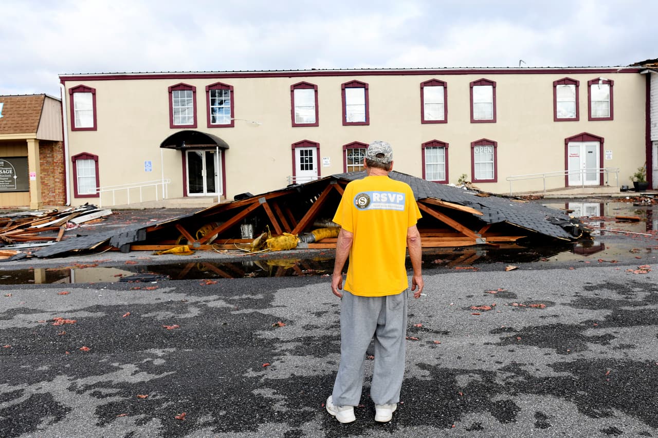 Kenny Smith observa el techo de un apartamento que fue arrancado por los efectos del huracán Isaias y cayó frente a su vivienda el sábado 10 de octubre de 2026 en East Milton, Florida.
<br>