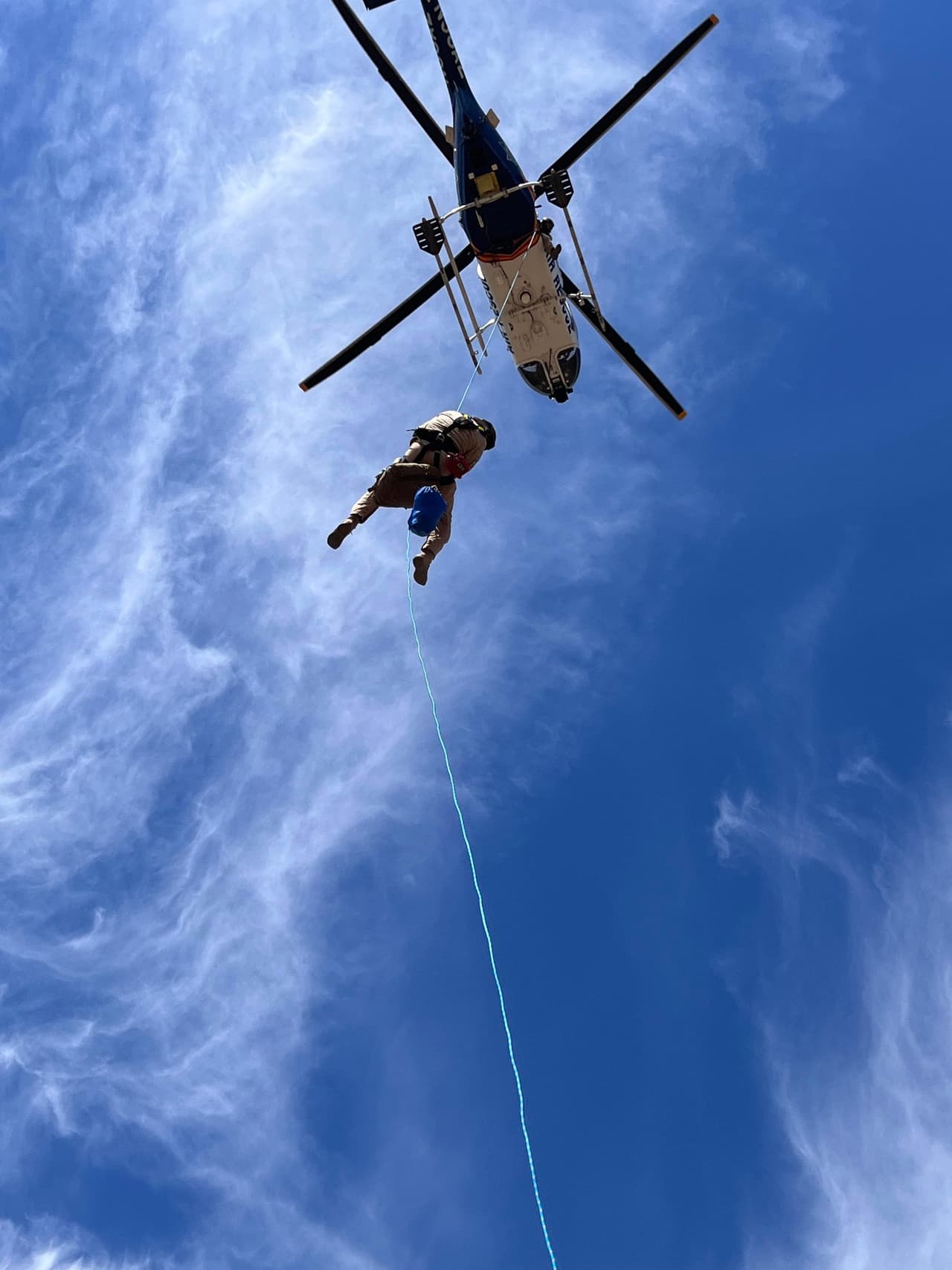 Luego, el helicóptero regresó y el especialista en rescate en entrenamiento hizo que otro médico descendiera en rappel desde el helicóptero hasta el excursionista herido para realizar una evaluación y prepararlo para una extracción de corta distancia, donde el médico que descendió en rapel está asegurado por una cuerda de 150 pies con el excursionista lesionado que estaba asegurado con un traje usado para una extracción rápida.