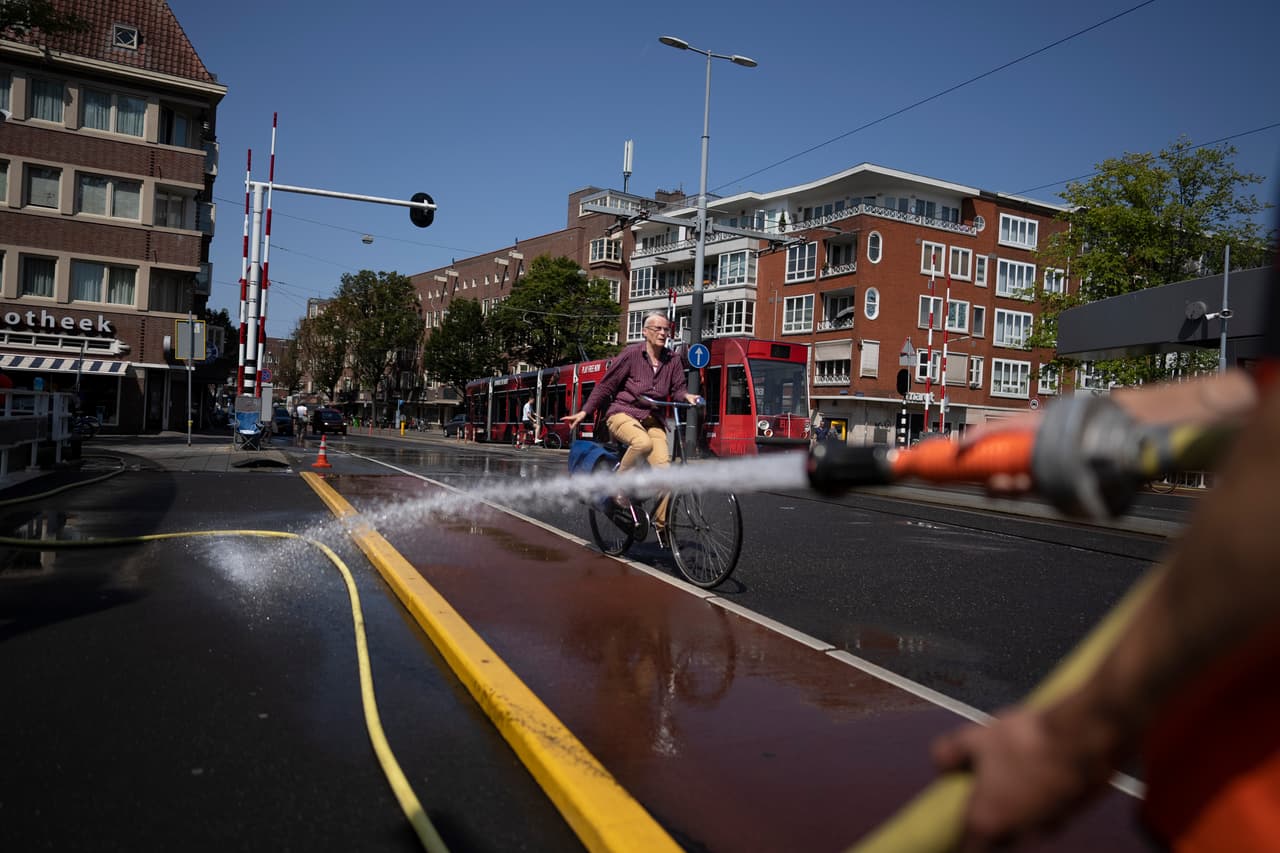 Trabajadores municipales de Amsterdam arrojan agua a los tradicionales canales de la ciudad para evitar que el metal de las construcciones se expanda y dificulte el tráfico de botes. La capital de los Países Bajos registró una temperatura máxima de 38º C (100.4º F) este martes.