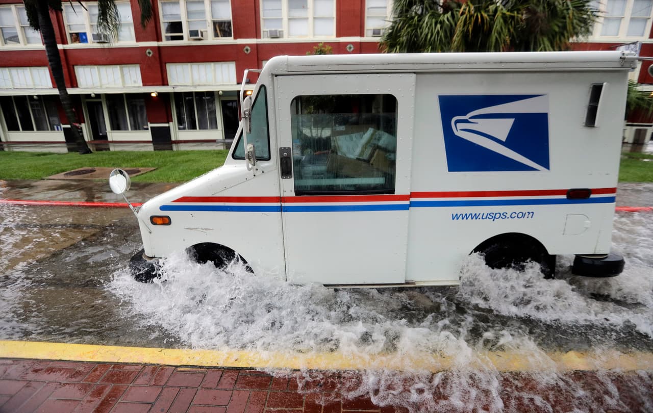 Un camión del servicio de correos se desplazaba por Galveston el miércoles cruzando una calle que quedó anegada por la tormenta.