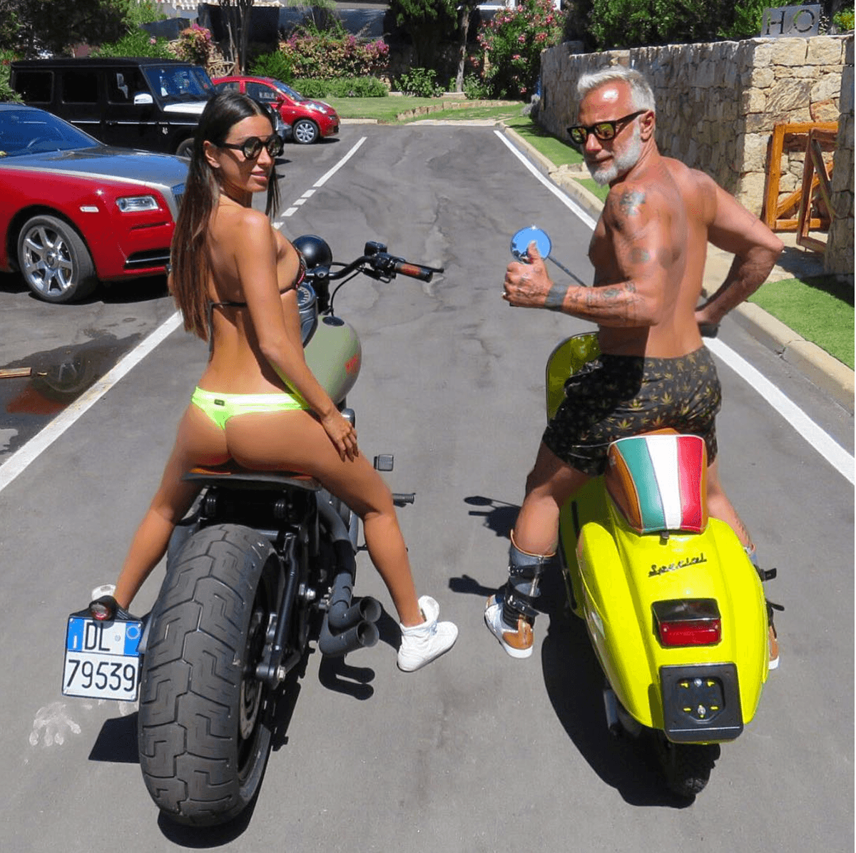 En esta imagen Giorgia aparece sobre la Harley Davidson mientras que Gianluca da la señal de aprobación a bordo de un pequeña
<b>Vespa</b> amarillo canario con el sillín decorado con los colores de la bandera de Italia.