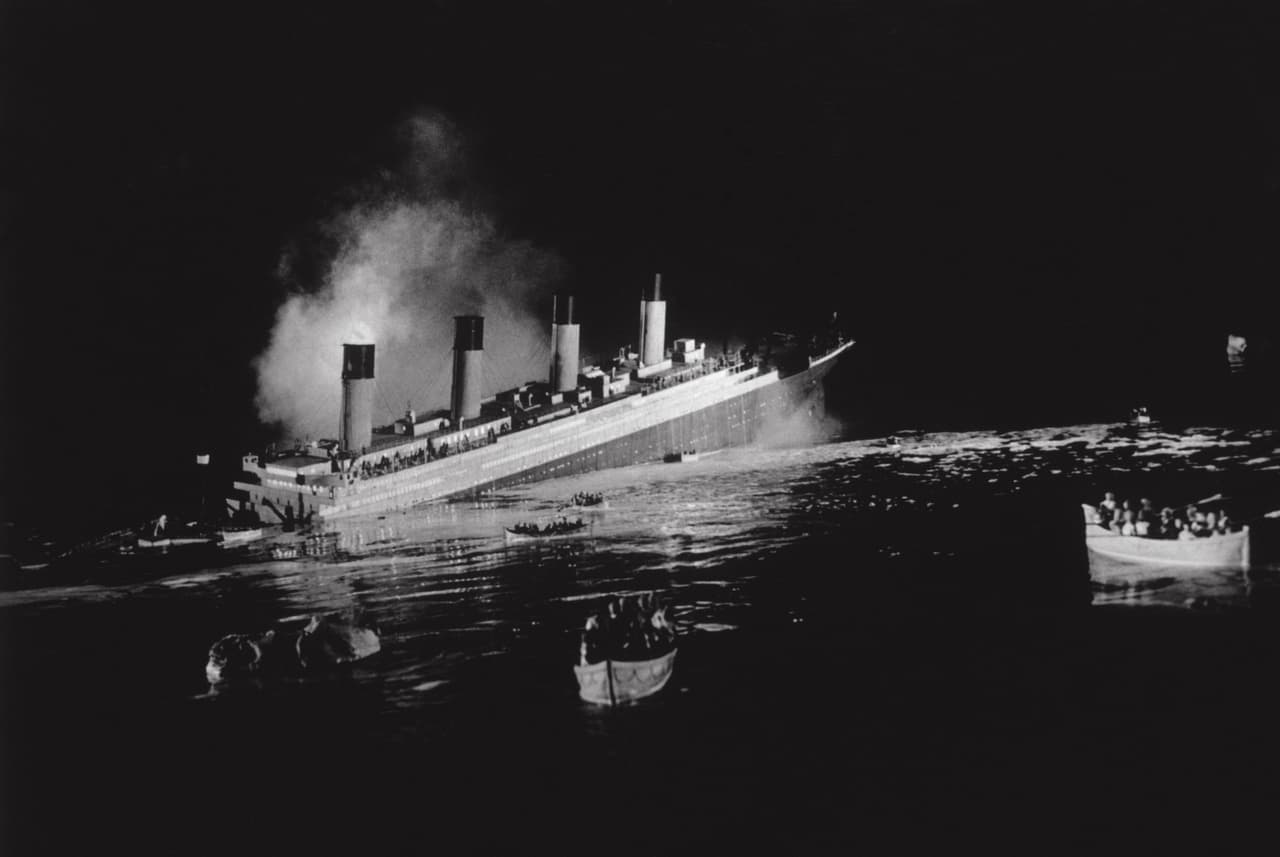 Los cuatro primeros días del viaje habían transcurrido sin contratiempos hasta que a la medianoche del 14 de abril un iceberg no pudo ser esquivado por la tripulación y el roce entre acero y el hielo provocó una ruptura fatal del casco. La imagen muestra al inmenso barco hundiéndose mientras los botes salvavidas llevan a algunos afortunados.