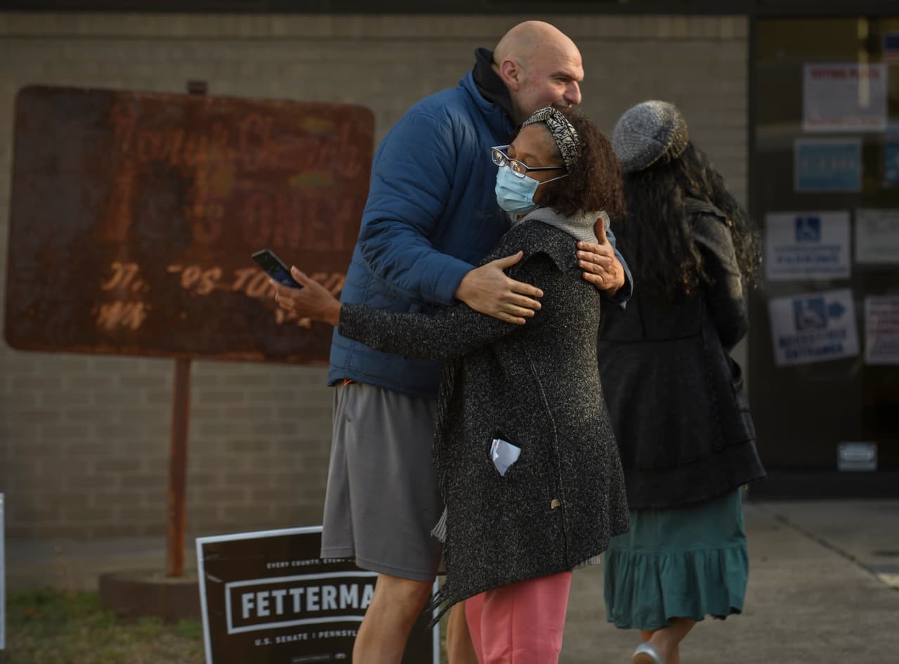 El candidato demócrata al Senado de Pensilvania, John Fetterman, abraza a un votante mientras él y su esposa, Gisele, ingresan a su lugar de votación.