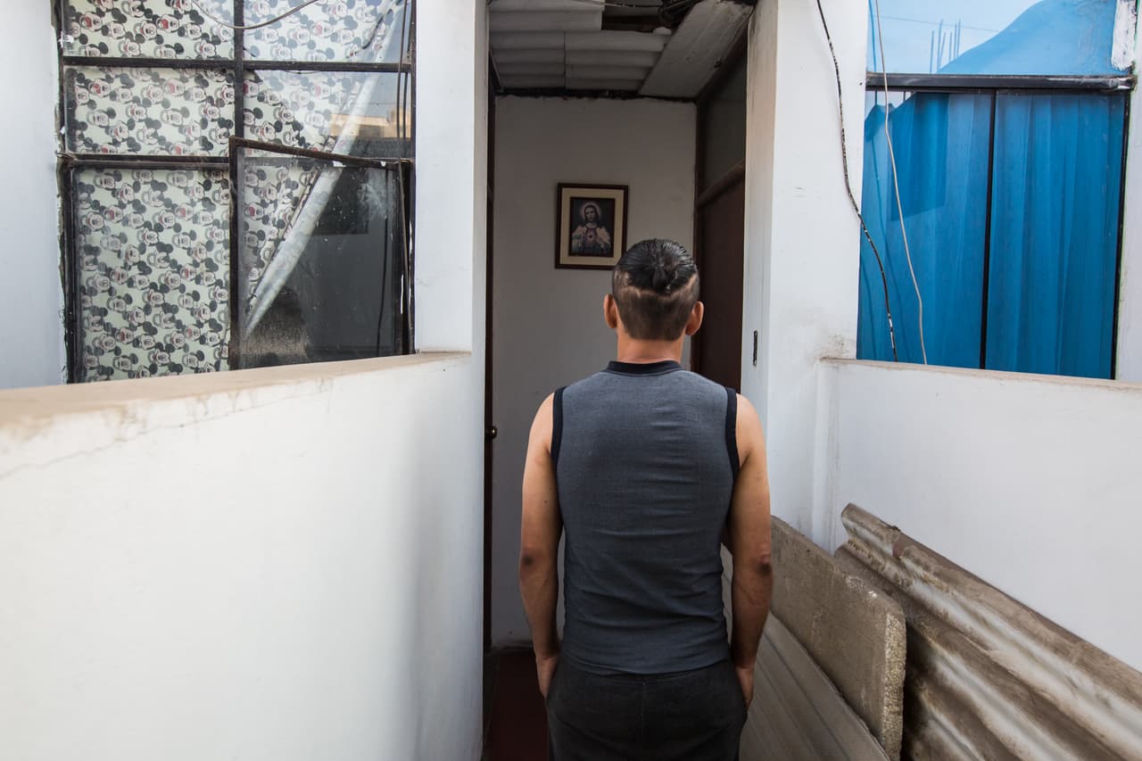 “En algo debemos creer”, dice el migrante frente a la imagen del Sagrado Corazón de Jesús en el pasillo del lugar donde vive.