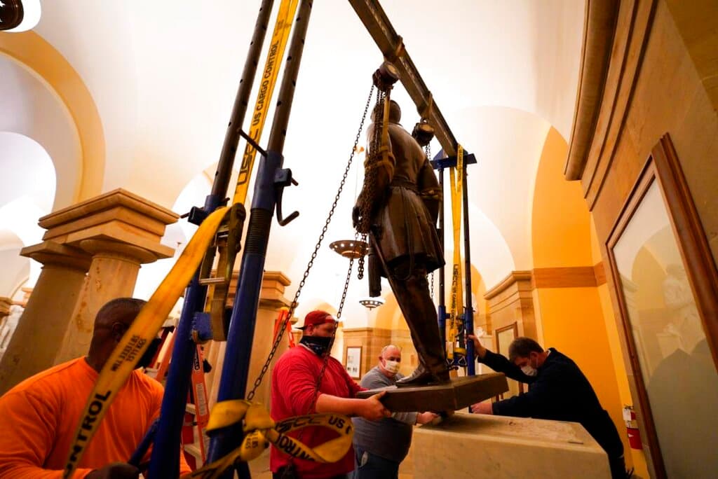 Unos trabajadores retiran la estatua del general confederado Robert E. Lee de la Sala Nacional de Estatuas del Capitolio, en Washington, el lunes 21 de diciembre de 2020.