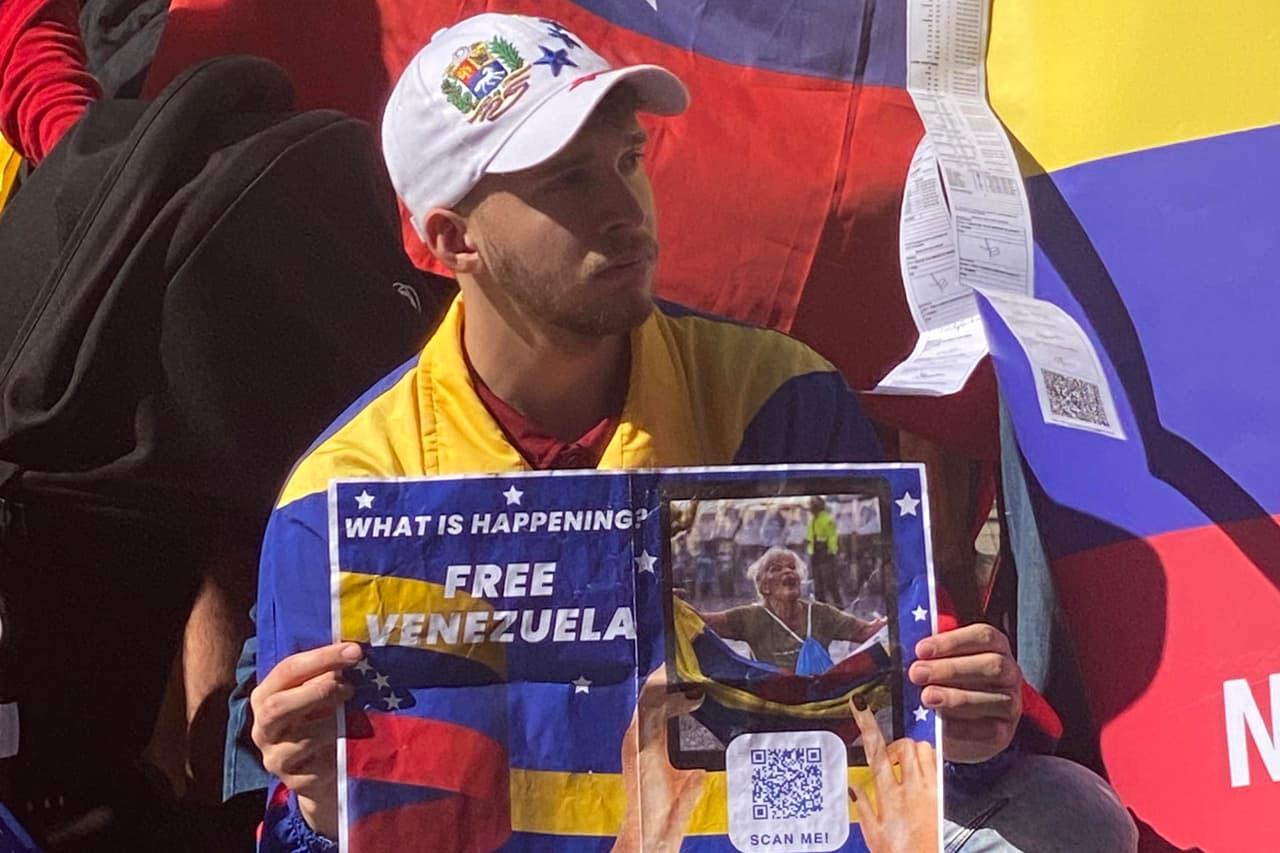 Un venezolano sostiene un cartel durante una protesta este sábado en el centro de Sídney (Australia).