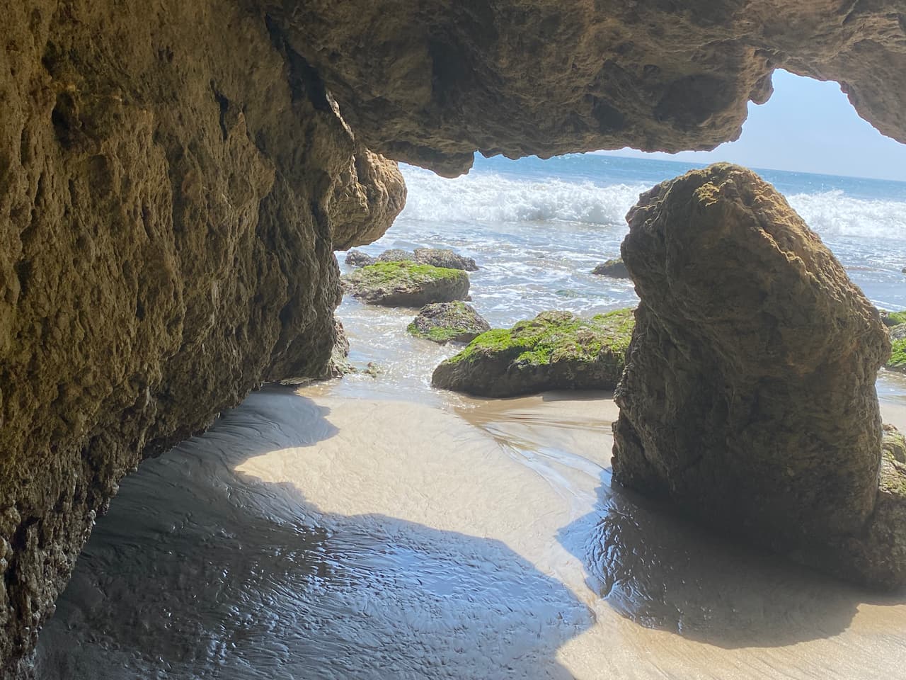 En días de calor extremo, la cueva marina sirve de refugio natural para los visitantes de la playa.