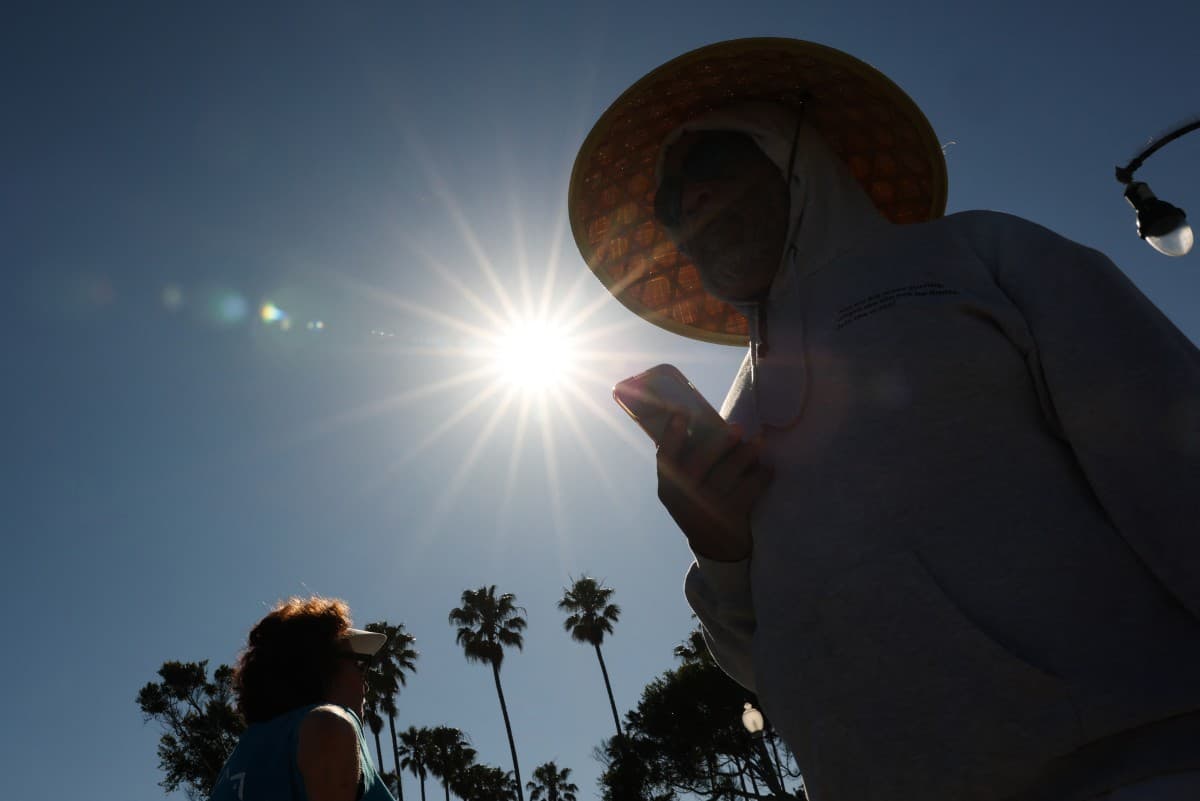 Una persona lleva un sombrero para protegerse del sol matutino mientras camina por The Strand en Redondo Beach, California, el 20 de marzo de 2026, durante una ola de calor.