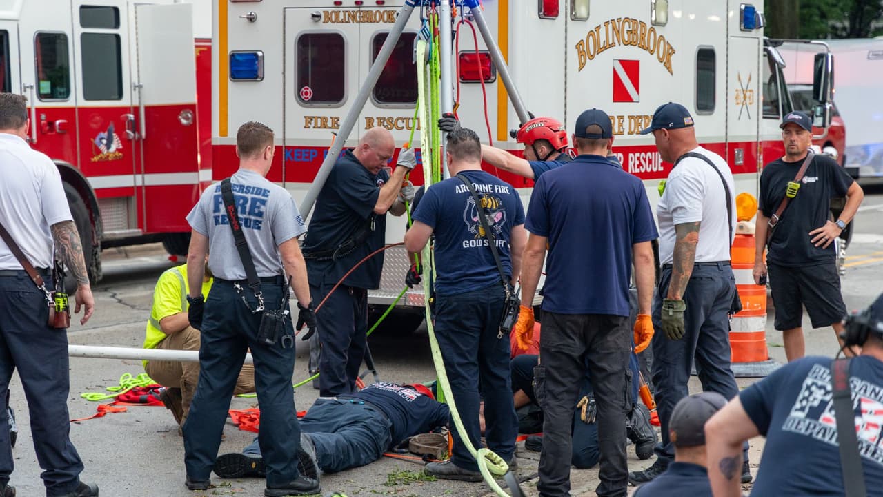 Bomberos de Downers Grove trabajan en la zona del incidente ocurrido el lunes durante una fuerte tormenta, cuando el contratista Iván A. Pérez, de 33 años, fue arrastrado por la corriente y quedó atrapado en una alcantarilla pluvial; su cuerpo fue recuperado más de 24 horas después.