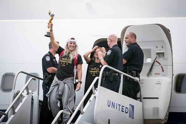 Julie Ertz baja del avión en el aeropuerto de Newark con trofeo en mano, después de que la selección femenina de fútbol de Estados Unidos hubiera ganado la Copa Mundial, celebrada este año en Francia.
<br>