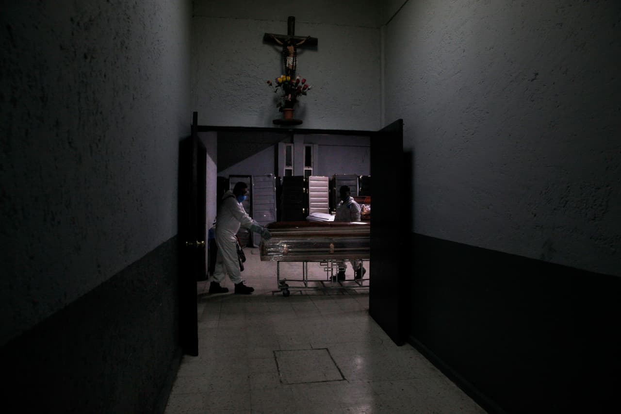 Trabajadores con equipo de protección en medio de la nueva pandemia de coronavirus empujan los restos de una persona al crematorio dentro del cementerio Panteón de San Nicolás Tolentino en el barrio de Iztapalapa, Ciudad de México.