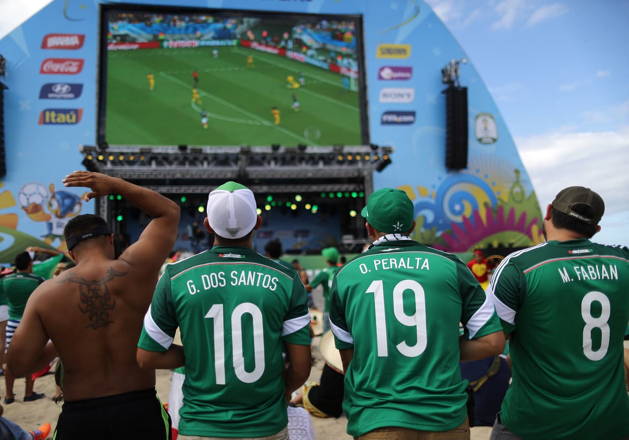 Aficionados mexicanos al fútbol observan el partido del Mundial entre México y Camerún dentro del área del FIFA Fan Fest en la playa de Copacabana en Río de Janeiro, Brasil.